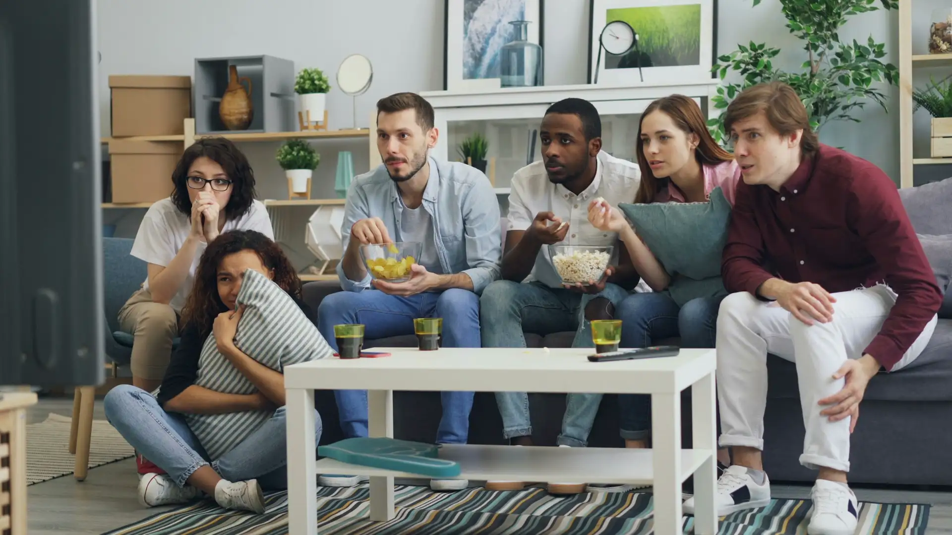 Family watching live TV together on the sofa